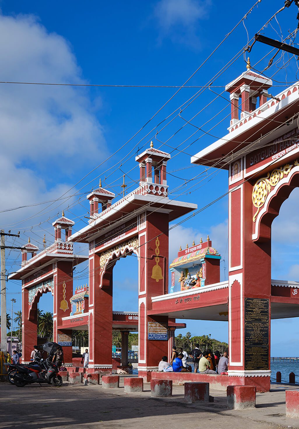Agnitheertham shore with temple steps leading into the sea at Rameswaram under clear sky